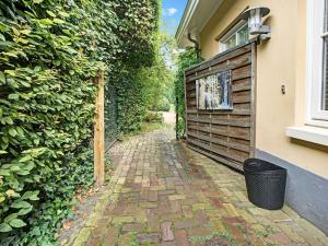 a brick walkway next to a building with a fence at Picturesque Holiday Home in Oldenzaal with Jacuzzi in Oldenzaal