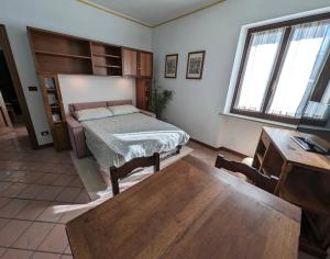 Schlafzimmer mit einem Bett, einem Schreibtisch und einem Tisch in der Unterkunft Sentirsi a casa in Verzuolo