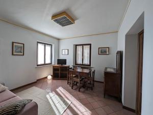 ein Wohnzimmer mit einem Tisch und einem Schreibtisch in der Unterkunft Sentirsi a casa in Verzuolo