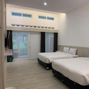 Cette chambre dispose de deux lits et d'un balcon. dans l'établissement Tambi Tea Resort, à Kejajar