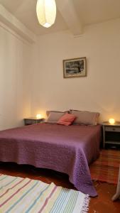 a bedroom with a large purple bed with two tables at La belle des Remparts in Sérignan