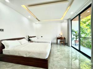sypialnia z 2 łóżkami i oknem w obiekcie Tropikult Homestay w mieście Thôn Kim Long (1)