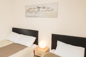 サウスエンド・オン・シーにあるSouthend Guest House - Close to Beach, Train Station & Southend Airportのベッドが2つあり、壁に絵が飾られた寝室 +16枚の写真