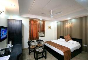 Habitación de hotel con cama y TV en Hotel Jeniffer Inn en Nueva Delhi