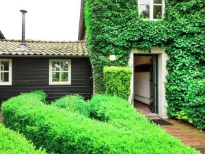 a house with ivy growing on the side of it at Cozy group house in Reusel in a natural environment in Lage Mierde