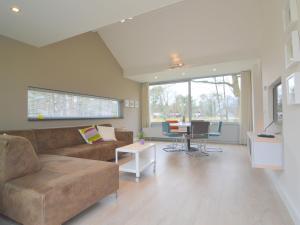 a living room with a couch and a table at Alluring Holiday Home in Limburg near Forest in De Horst