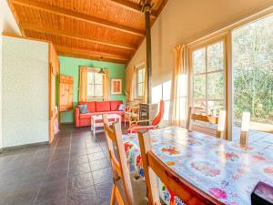 comedor con mesa, sillas y sofá en Tranquil Holiday Home in Lage Zwaluwe with Terrace, en Lage Zwaluwe