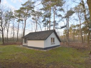 una pequeña casa en medio de un campo en Completely detached bungalow in a nature filled park by a large fen, en Stramproy