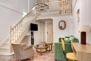 a living room with a green couch and stairs at Hôtel La Grande Bastide - Teritoria in Saint Paul de Vence