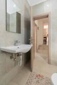 La salle de bains est pourvue d'un lavabo blanc et d'un escalier. dans l'établissement Paradise House, à Neos Marmaras