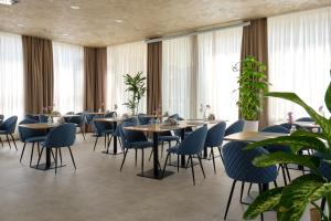 a restaurant with tables and chairs and windows at STYLO Residences & Suites in Tashkent