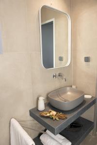 een badkamer met een wastafel en een spiegel bij Villa Margarita in Kateliós