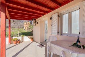 a balcony with a table and a view of the yard at Paradise House in Neos Marmaras