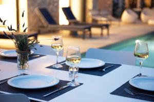 een tafel met drie glazen witte wijn erop bij Villa Margarita in Kateliós