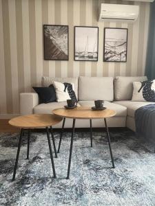 a living room with two tables in front of a couch at Blue Apartament - HOME APART in Ostróda
