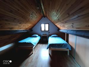 2 Betten in einem kleinen Zimmer mit Fenster in der Unterkunft Maison Bressanne in Sornay