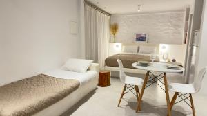 a bedroom with a bed and a table and chairs at Mykonos Tourlos Nests - Sea View Escape in Tourlos