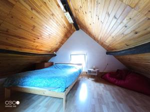 Bett in einem Zimmer mit Holzdecke in der Unterkunft Maison Bressanne in Sornay