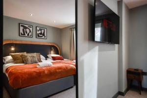 a bedroom with a bed with a flat screen tv at May Disc - Long Stay - Contractors in Bristol