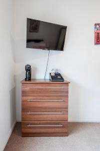a dresser with a flat screen tv on a wall at Dazzling Room near Paddington/Elizabeth Stn in London