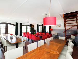 a dining room with red chairs and wooden tables at Atmospheric country house in Asten on a golf course in Asten