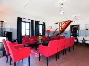 a dining room with red chairs and a table at Atmospheric country house in Asten on a golf course in Asten