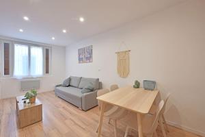 un soggiorno con un tavolo e un divano di Studio Andréa - Proche Théatres et Place des corps saints - WIFI ad Avignone