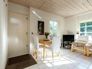 オーストカペッレにあるQuaint Apartment in Oostkapelle Zealand with Terraceのダイニングルーム(テーブル、白い椅子付)