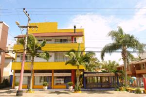 un edificio amarillo con palmeras delante en Solar Diamantina Apartamentos, en Florianópolis
