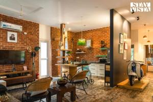 - un salon avec un mur en briques dans l'établissement StayVista at Home By The Pinakini - The Hidden Gem, à Whitefield