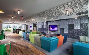 a lobby with colorful chairs and a tv on a wall at Blueground Somerville gym wd nr T station BOS-1039 in Somerville