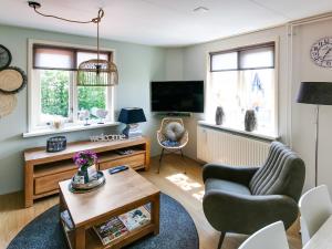 sala de estar con sofá y TV en Beautiful Apartment in Callantsoog near Beach, en Callantsoog