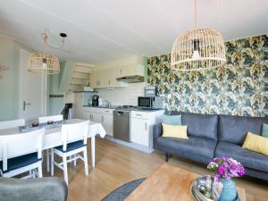 uma sala de estar com um sofá azul e uma mesa em Beautiful Apartment in Callantsoog near Beach em Callantsoog