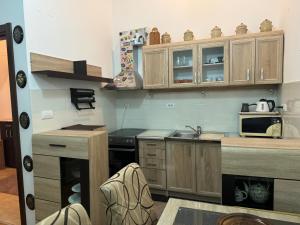 a small kitchen with wooden cabinets and a microwave at Apartment 50 in Podgorica
