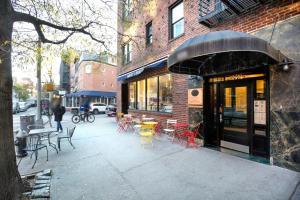 a sidewalk with tables and chairs outside of a restaurant at West Village 1br w wd nr bars restaurants NYC-1133 in New York
