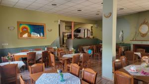 un restaurant avec des tables et des chaises et une peinture arc-en-ciel sur le mur. dans l'établissement PANTHEON HOLIDAY INN, à Kamena Vourla