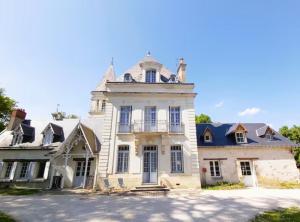 a large white house with a tower on top of it at Un séjour au Manoir sud Tours in Chambray-lès-Tours