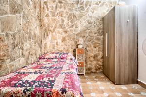 een slaapkamer met een bed en een stenen muur bij Cueva Alicante in Alicante