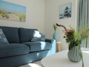uma sala de estar com um sofá e uma mesa com um vaso de flores em Stunning apartment in Schoorl North Holland you can bike to the beach em Schoorl