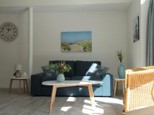 a living room with a blue couch and a table at Stunning apartment in Schoorl North Holland you can bike to the beach in Schoorl