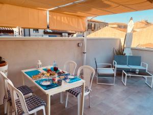 a table and chairs with food on a patio at Royal House in Catania