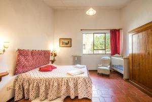 een slaapkamer met een bed en een raam bij Casalino in Castelnuovo Berardenga