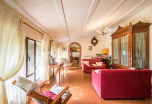 een woonkamer met een rode bank en een tafel bij Casalino in Castelnuovo Berardenga
