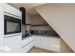 a kitchen with white cabinets and a stove at Appealing apartment in Domburg near the beach in Domburg