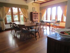 a dining room with a table and chairs and windows at The Sleeping Bao B&B in Pietermaritzburg