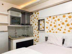 Cet appartement comprend une chambre avec un lit et une cuisine. dans l'établissement RedLiving Apartemen Bogor Valley - Paulina Property Tower A, à Kalibata 1