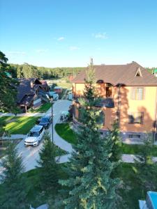 a house with a car parked in a parking lot at Osobnyak in Shchūchīnsk