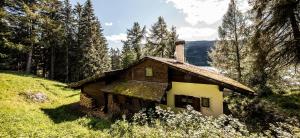 an old house on a hill in the woods at Chalet am Reschensee in Resia