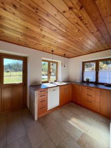 a large kitchen with wooden ceilings and wooden counters at Ferienhaus an der Drau in Sankt Oswald