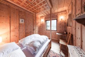 a bedroom with two beds in a wooden cabin at Chalet am Reschensee in Resia